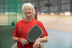 Femme agée qui fait du padel
